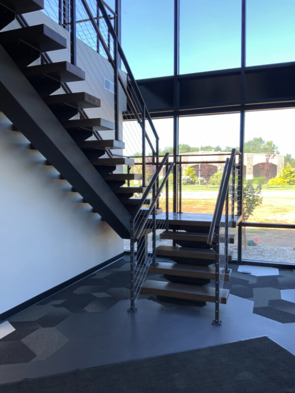 Multi-level indoor steel stair with cable railings for commercial spaces