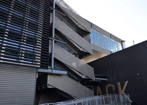 An outdoor U-shaped staircase featuring a distinctive horizontal louvered exterior.